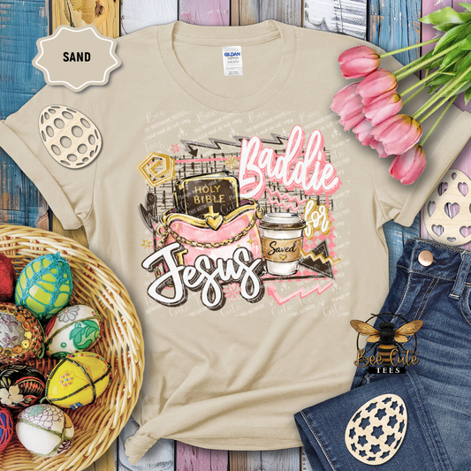 Beige t-shirt with 'Baddie for Jesus' design, surrounded by Easter decorations on a wooden surface.