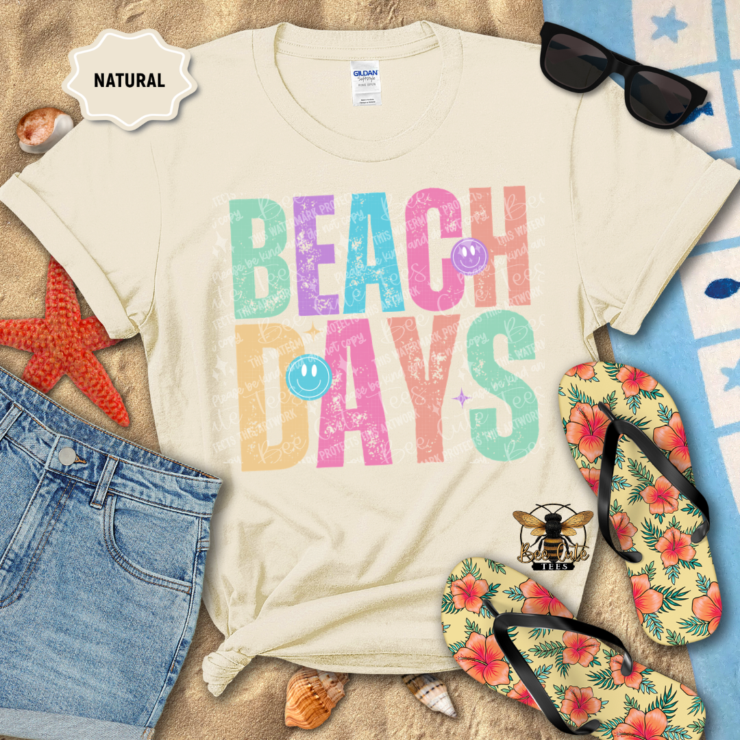 Beach-themed t-shirt with 'Beach Days' text, sunglasses, flip-flops, and beach accessories on a sandy background.