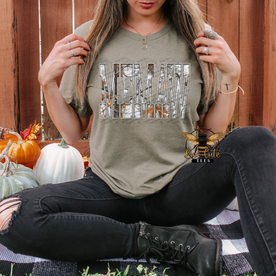 Person wearing a green t-shirt with a graphic design, sitting outdoors with pumpkins in the background.