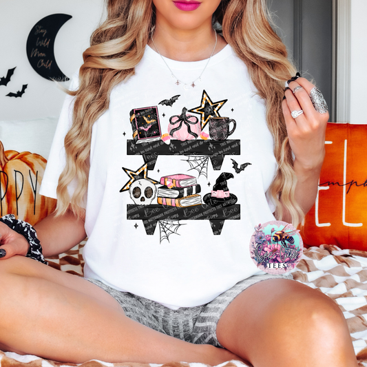 Person wearing a white t-shirt with Halloween-themed graphics, sitting on a couch.