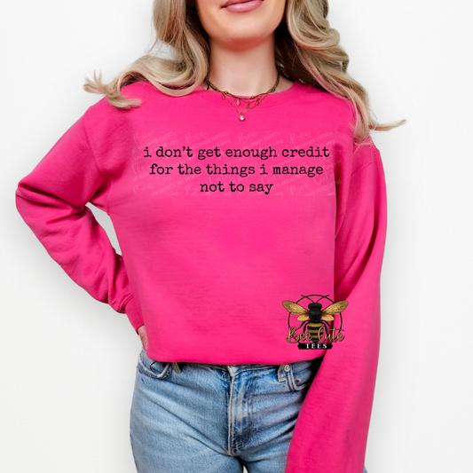Person wearing a pink sweatshirt with text and a logo on a white background