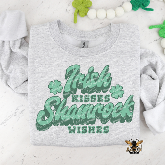 Gray t-shirt with 'Irish Kisses, Shamrock Wishes' text and clover graphics on a white background.
