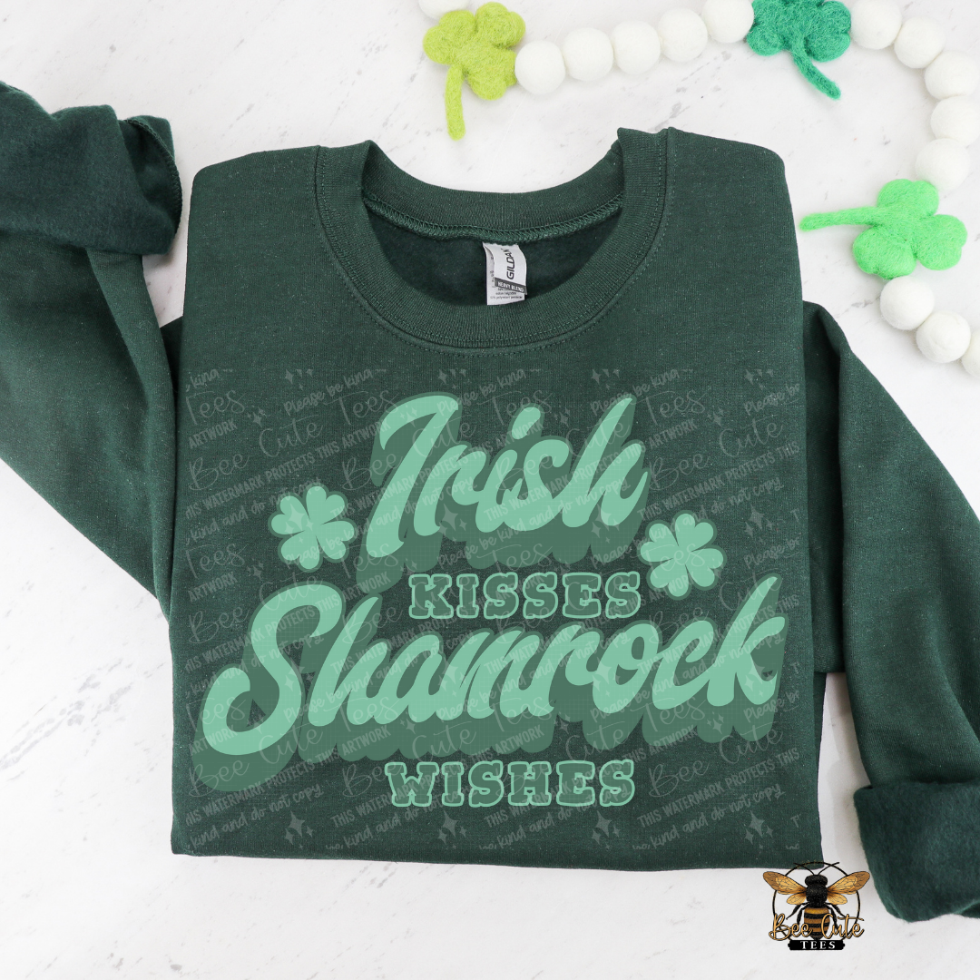 Green sweatshirt with 'Irish Kisses Shamrock Wishes' text on a white background with decorative elements.