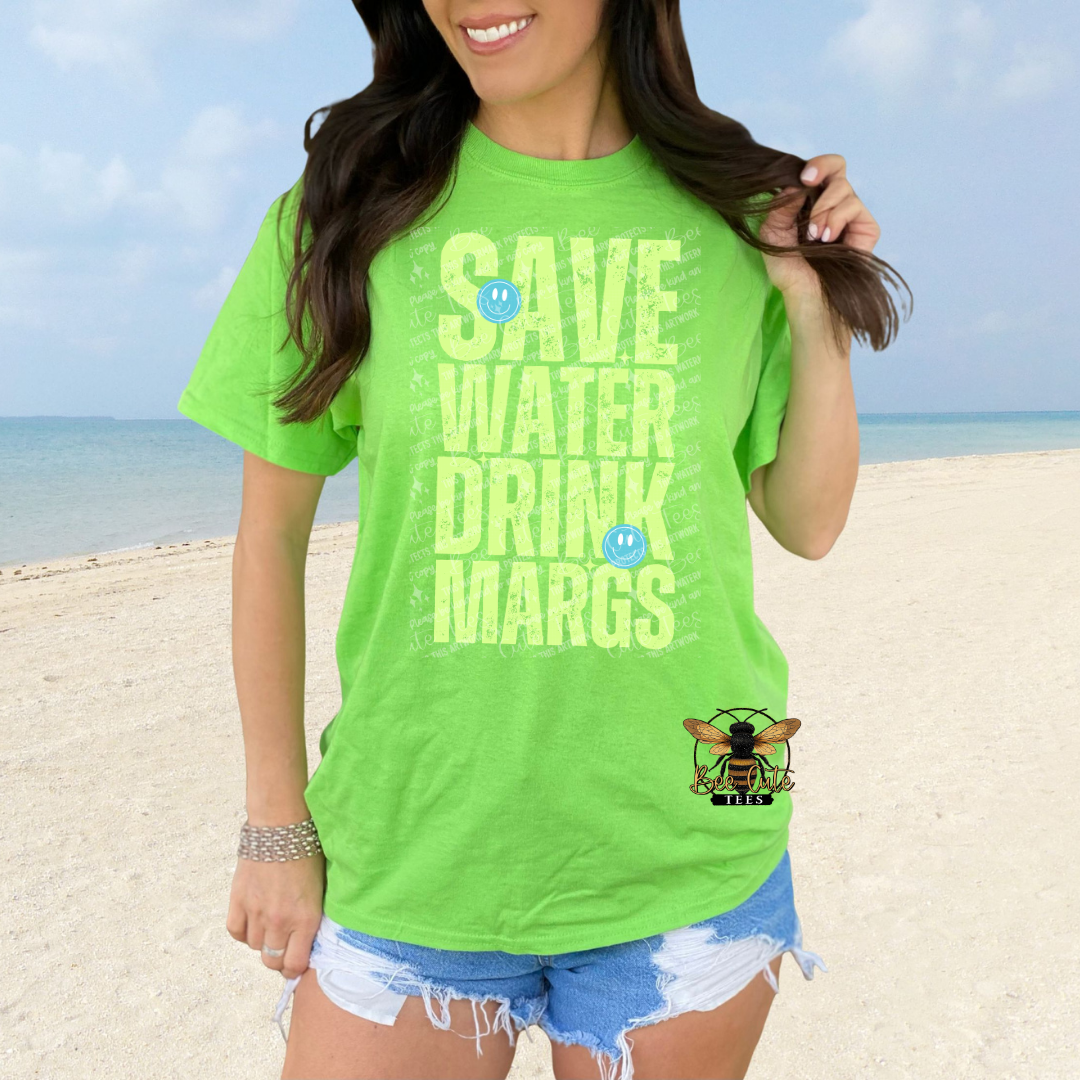 Person wearing a bright green t-shirt with 'SAVE WATER DRINK MARGS' text on a beach.