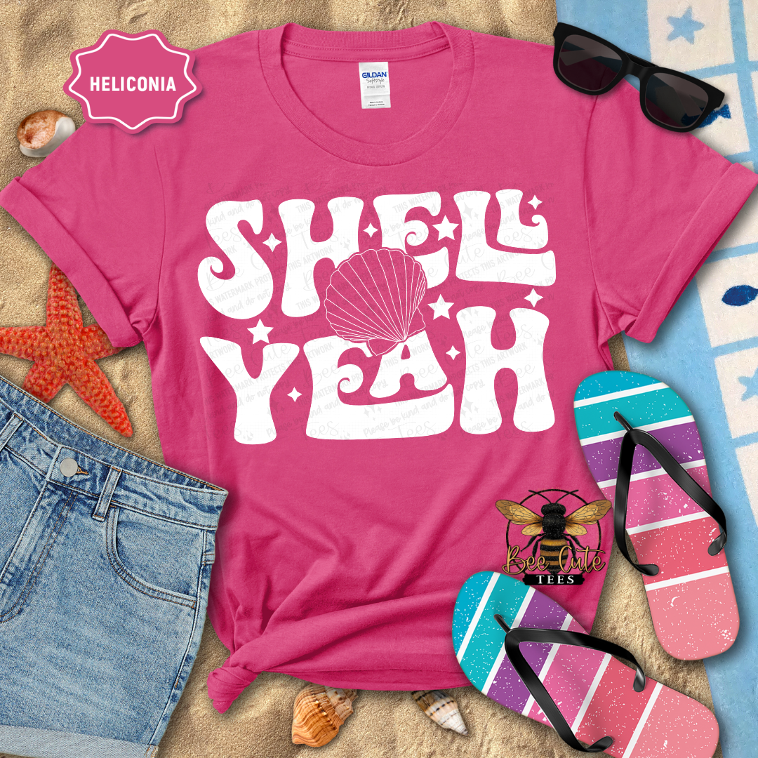 Pink t-shirt with 'Shell Yeah' design on a beach-themed background with sunglasses, flip-flops, and starfish.