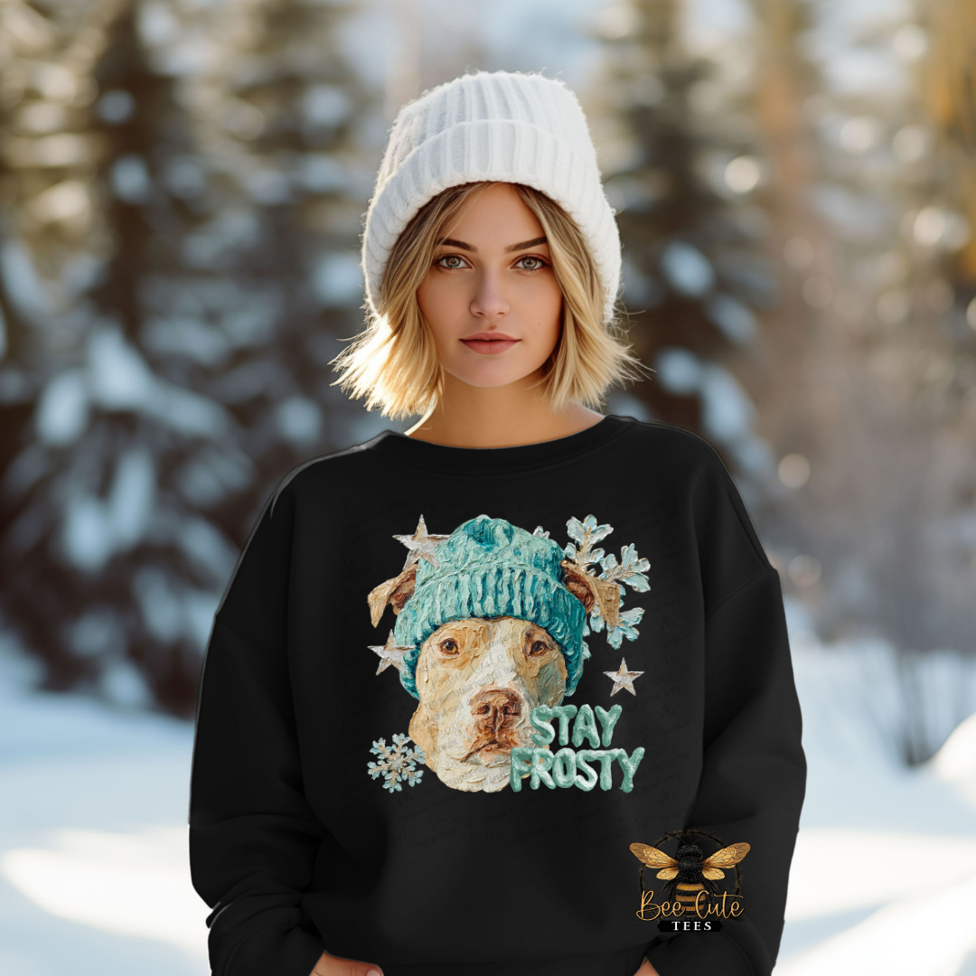 Person wearing a black sweatshirt with a dog graphic and 'Stay Frosty' text in a snowy landscape.