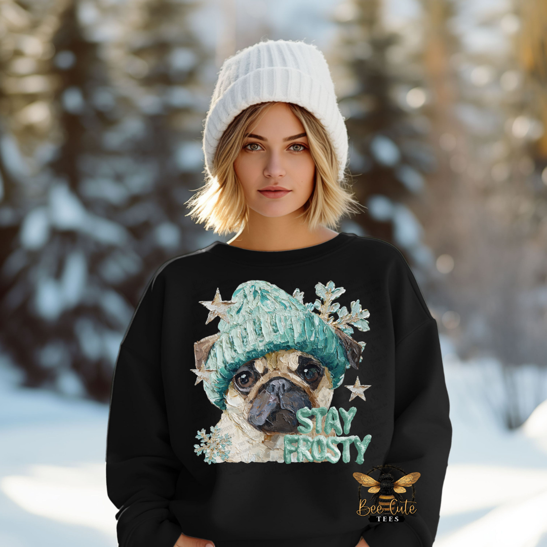 Person wearing a black sweater with a pug graphic and 'Stay Frosty' text in a snowy landscape.