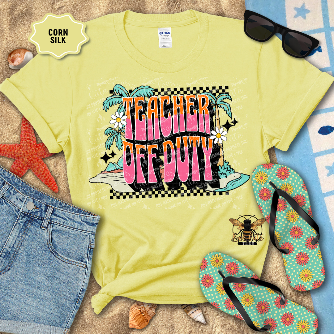 Yellow t-shirt with 'Teacher Off Duty' design on a beach setting with sunglasses, flip-flops, and denim shorts.