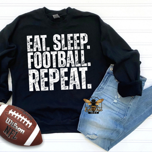 A black crewneck sweatshirt with the distressed white text 'EAT. SLEEP. FOOTBALL. REPEAT.'