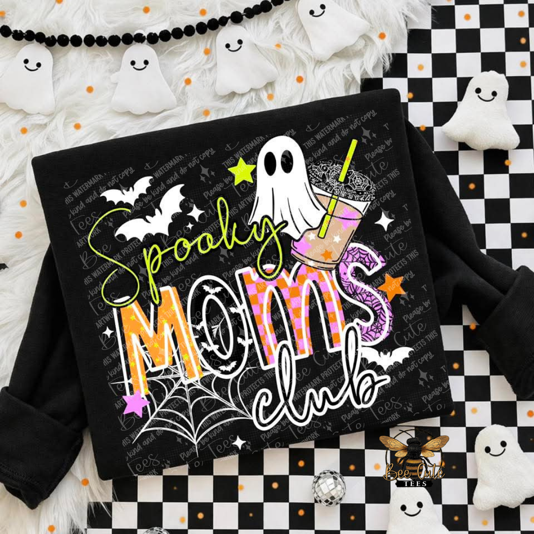 A black long-sleeve sweatshirt laid flat on a Halloween-themed background. The front has a large graphic reading 'Spooky Moms club' with a ghost, drink, bats, spiderwebs, stars, and orange/black patterned lettering.