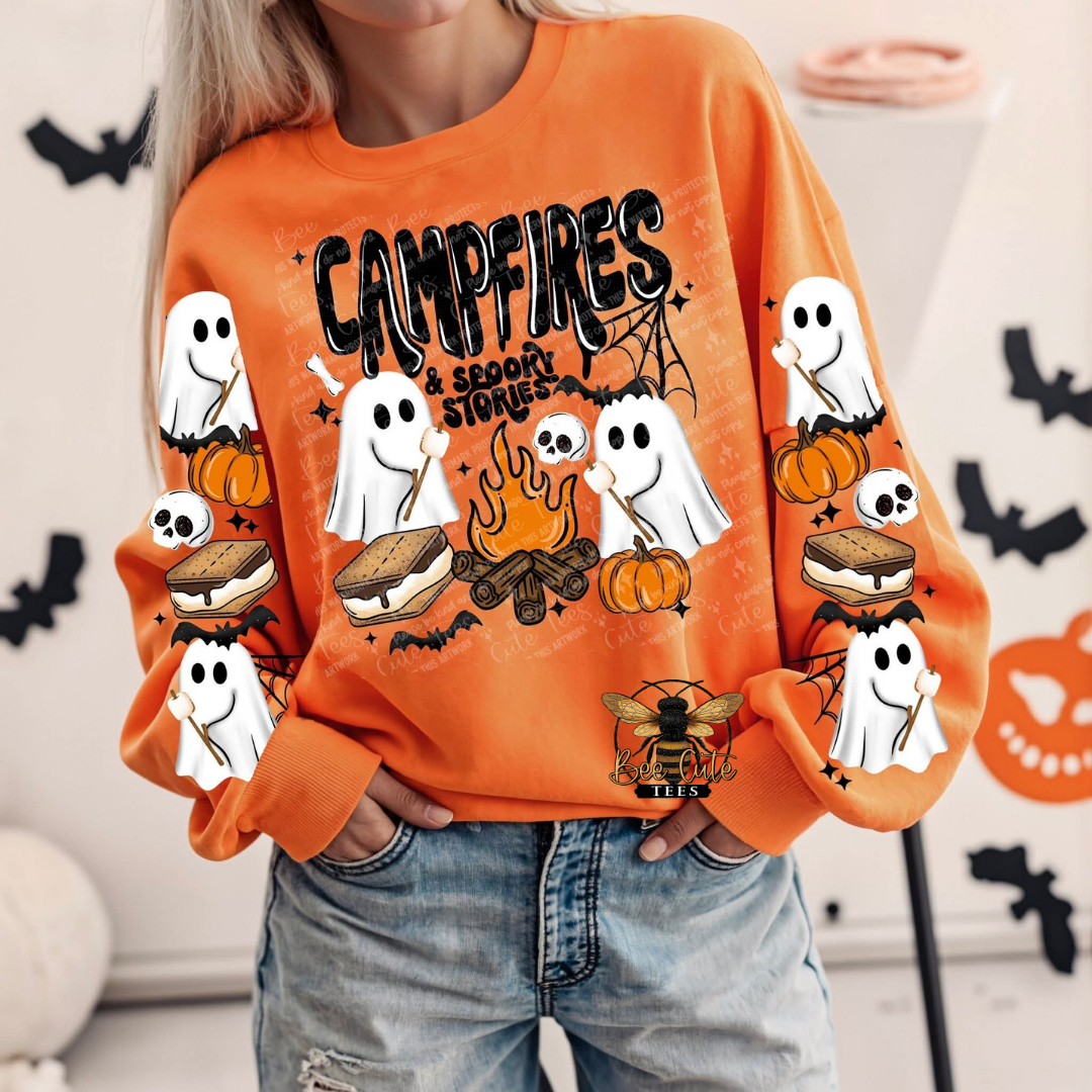 Orange Halloween sweatshirt featuring cute ghosts roasting marshmallows around a campfire with pumpkins, s’mores, skulls, bats, spiderwebs, and “Campfires & Spooky Stories” lettering, with coordinating ghost and s’mores designs on the sleeves.
