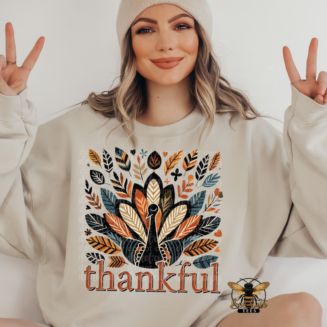 A woman wearing a beige crewneck sweatshirt with a colorful autumn turkey and leaf graphic and the word 'thankful' printed on the front, posing with peace signs against a light background.