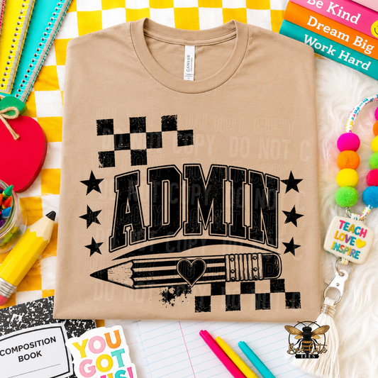 A beige graphic t-shirt featuring the word 'ADMIN' in bold black letters with a pencil and stars, styled in a flat-lay arrangement with school and office supplies.