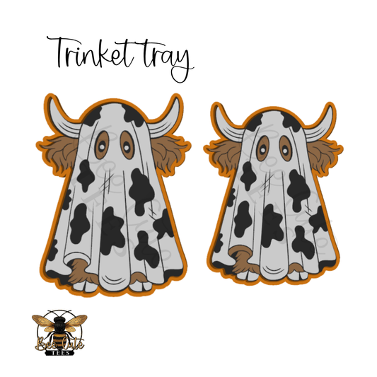 Two cartoon cow-and-ghost shaped trinket trays on a white background, with the text 'Trinket tray' above and a bee logo at bottom left.