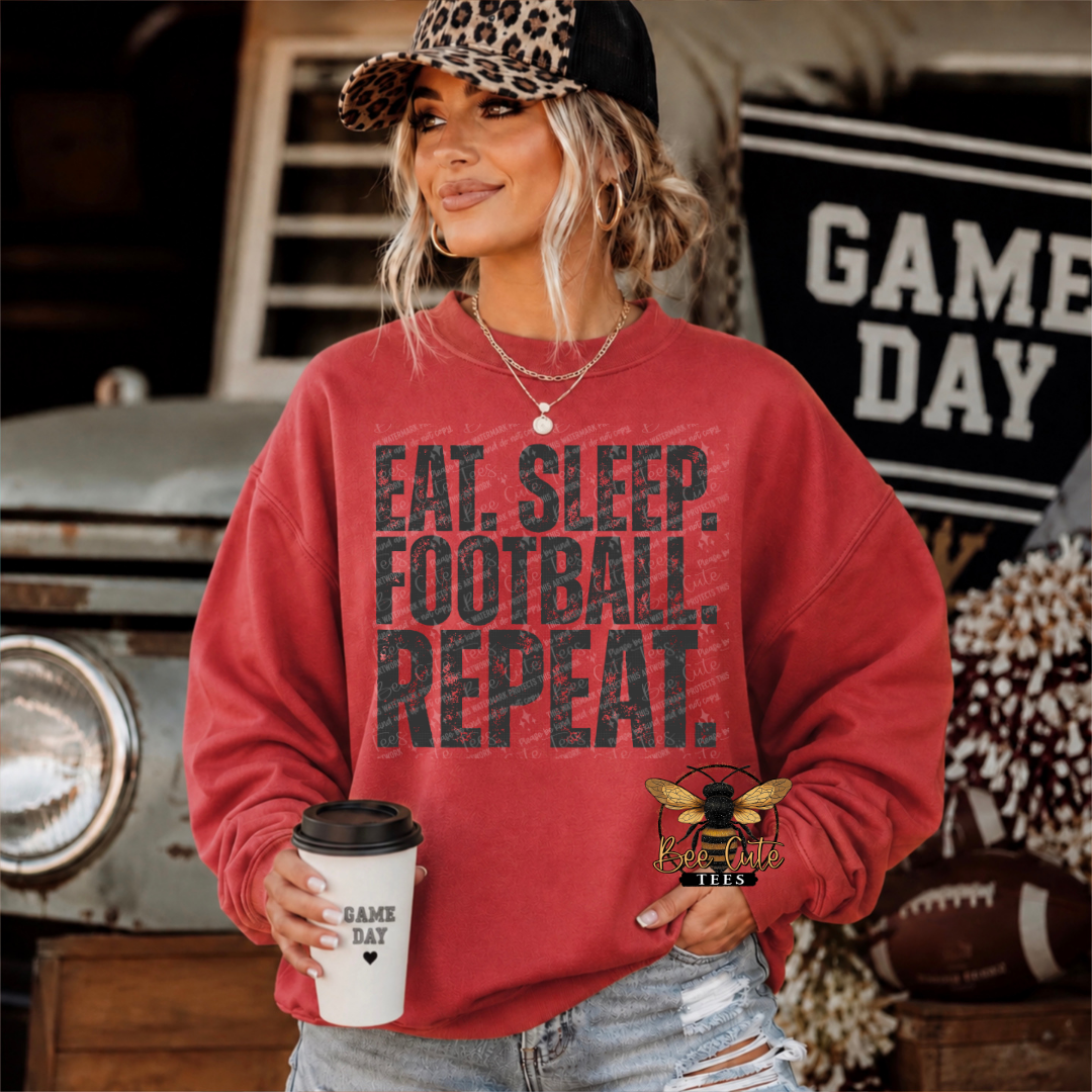 A woman wearing a red crewneck sweatshirt with the text 'EAT. SLEEP. FOOTBALL. REPEAT.