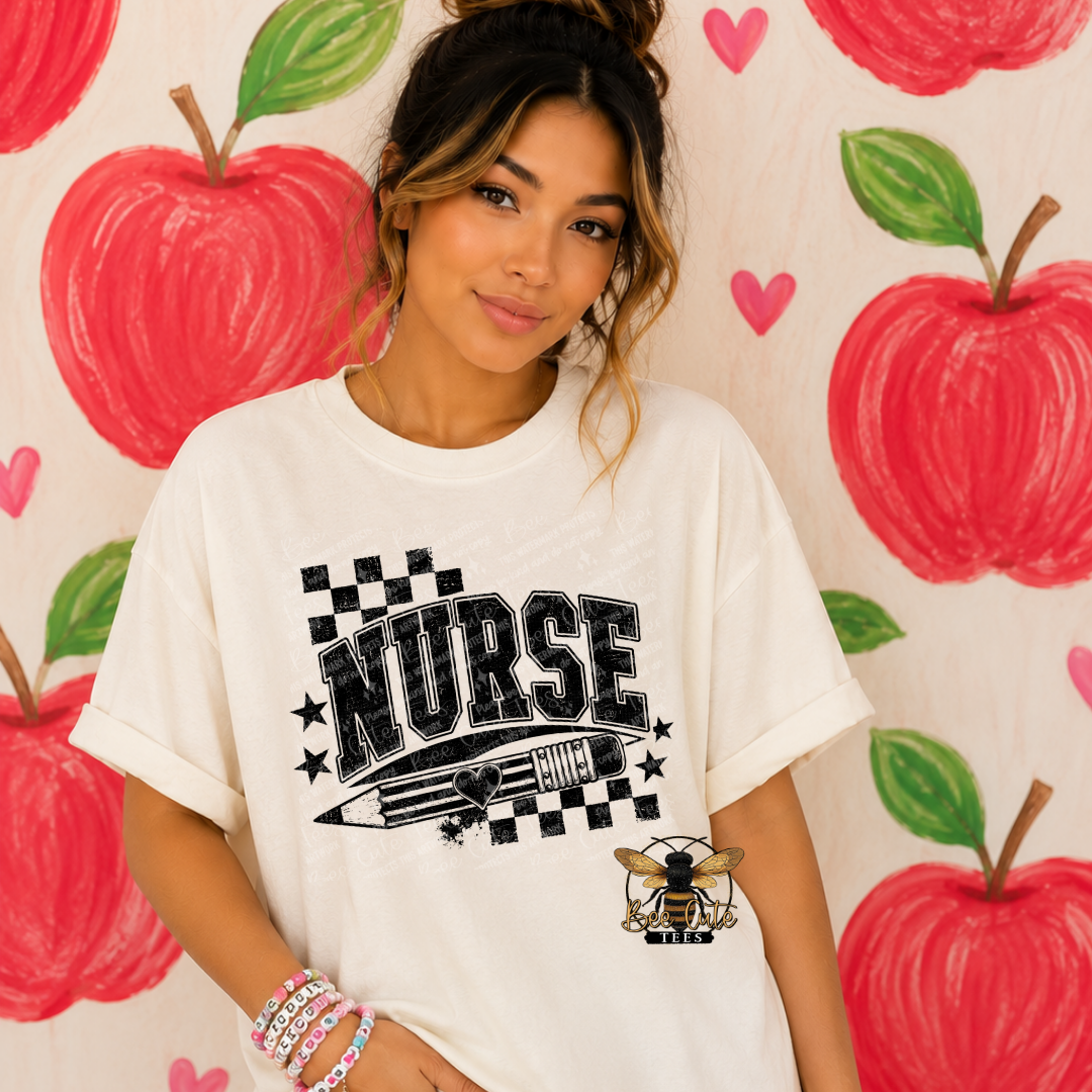 A woman wearing a white graphic t-shirt with 'NURSE' and a pencil design, posed in front of a wall covered in red apple illustrations.