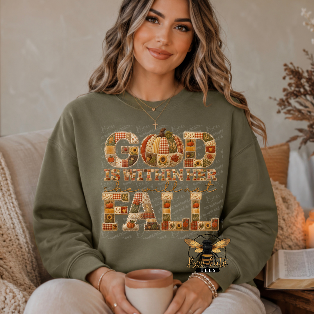 A woman wearing an olive green sweatshirt with a 'God is Within Her Heart of Fall' graphic, sitting in a cozy indoor setting and holding a mug.