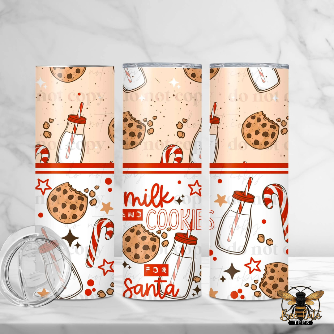 Three tall insulated tumblers with clear lids are shown on a light marble surface. The tumblers have a holiday cookie and milk design with illustrations of chocolate chip cookies, milk bottles, candy canes, stars, and the text 'milk and cookies for Santa'.
