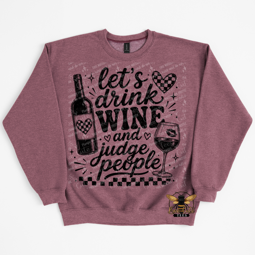 A heathered maroon crewneck sweatshirt featuring a black graphic print with the text 'let's drink WINE and judge people' alongside wine bottle, wine glass, and checkered heart motifs. With a small bee logo on the lower right front.