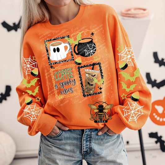 A woman wearing a bright orange long-sleeve sweatshirt with Halloween-themed graphics, including a ghost coffee mug, a black cauldron, a cat in a pumpkin, spiderwebs, bats, and the text 'COFFEE & spooky vibes'.