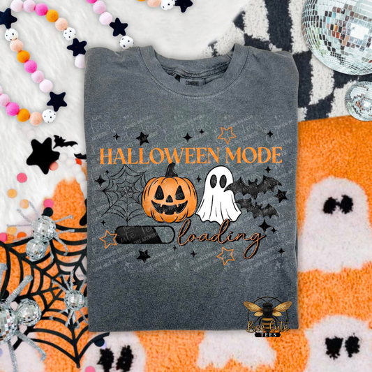 Gray t-shirt with Halloween-themed design featuring a pumpkin, ghost, and bat on a festive background.