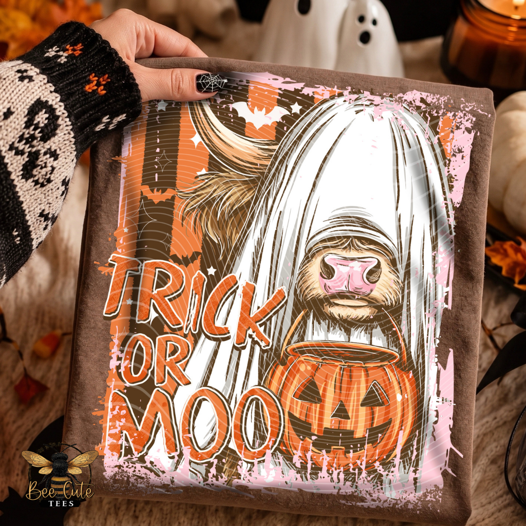 A person's hand holds a square custom canvas print featuring a cartoon sloth dressed as a ghost with the text 'TRICK OR MOO' and a jack-o'-lantern. The background is a cozy, warm-toned autumn setting with a ghost, pumpkins, and a candle.