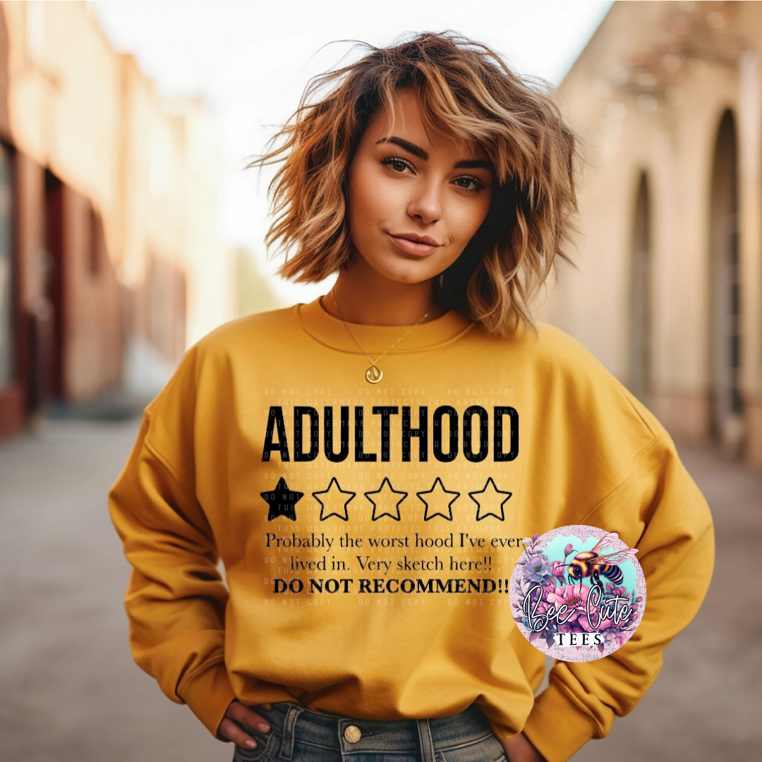 Person wearing a yellow sweatshirt with text about adulthood, standing in an outdoor setting.