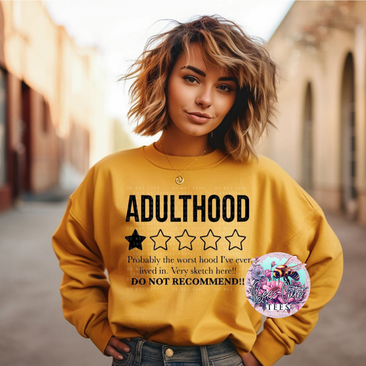 Person wearing a yellow sweatshirt with text about adulthood, standing in an outdoor setting.