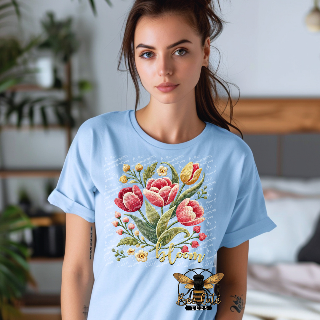 Woman wearing a light blue t-shirt with floral design and 'bloom' text.