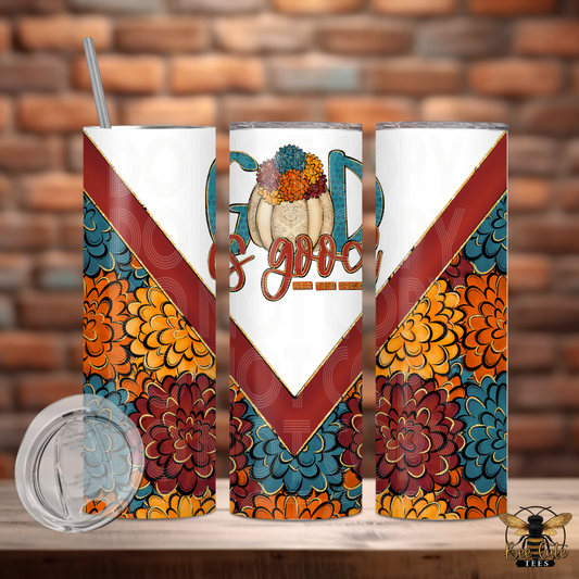 Three tall insulated tumblers with a white and autumn floral design, featuring a 'God is good' graphic on the center tumbler and a clear lid, displayed on a wooden surface against a brick wall background.