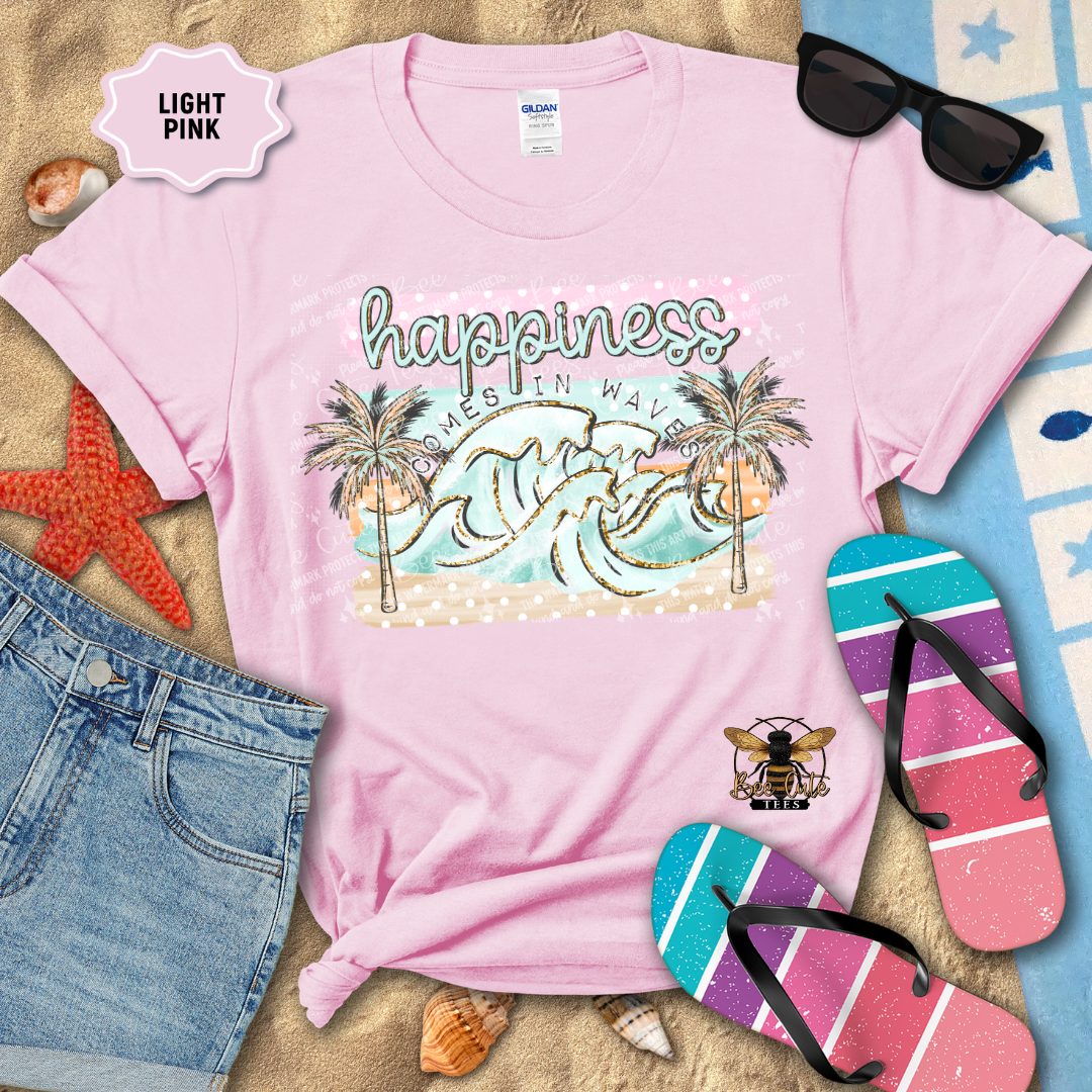 Light pink t-shirt with beach graphic and text, surrounded by flip-flops and sunglasses on a sandy background.