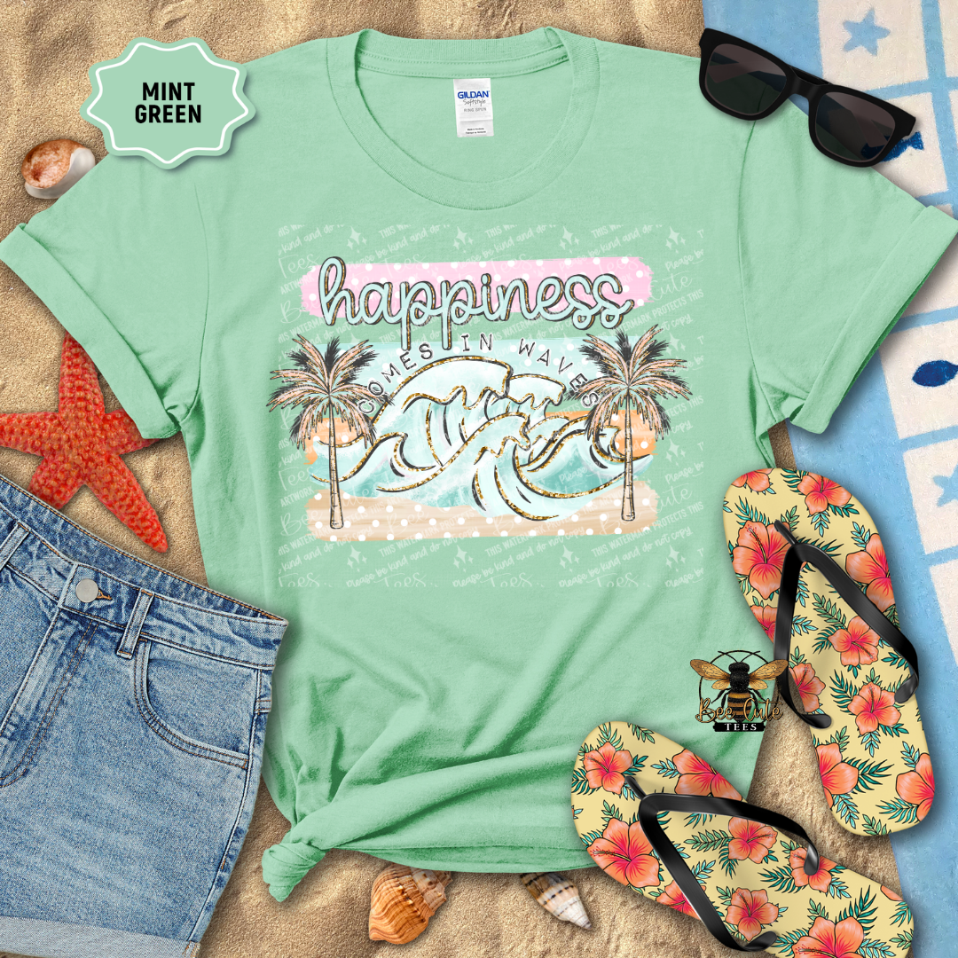 Mint green t-shirt with beach-themed design and accessories on a sandy background