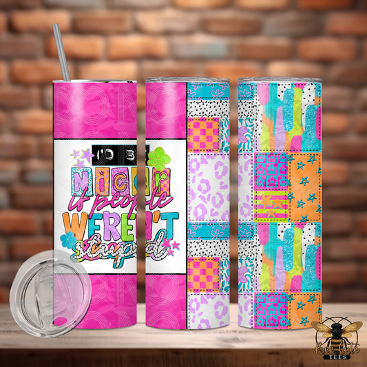 Three colorful tumblers with different designs on a wooden surface against a brick wall background.