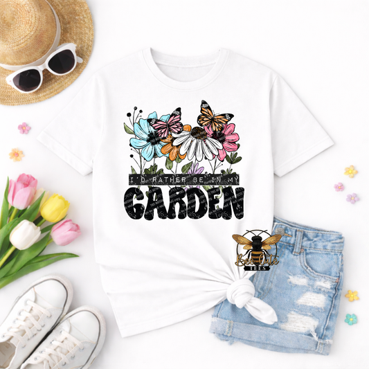 White t-shirt with floral design and text 'I'd rather be in my garden' on a white background with accessories.