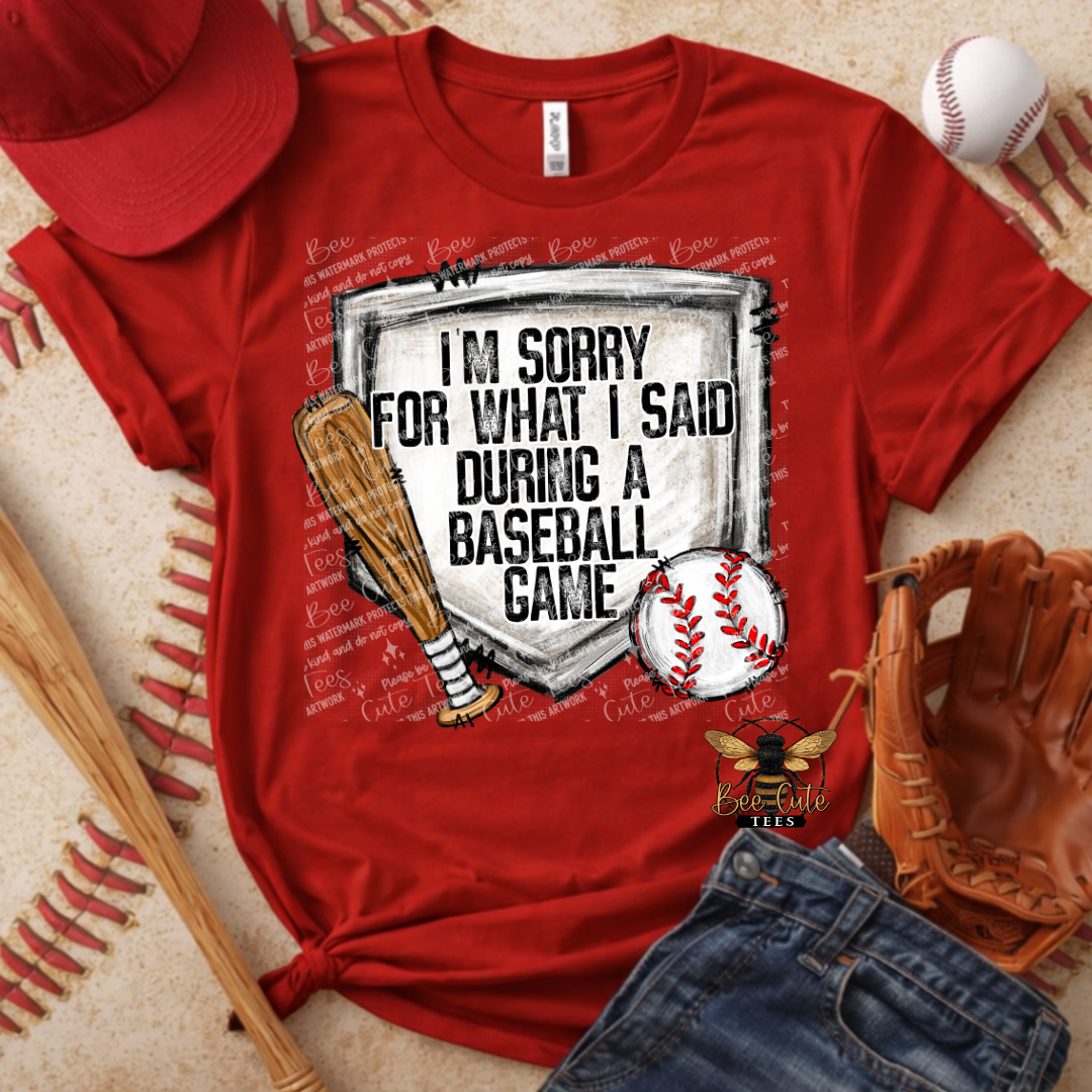 Red t-shirt with baseball-themed graphic and text, surrounded by baseball accessories on a textured surface.