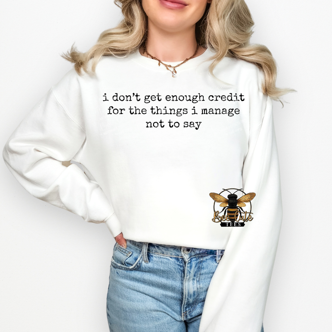 Person wearing a white sweatshirt with a bee logo and text on a plain background