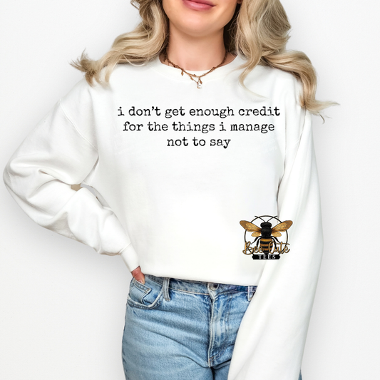 Person wearing a white sweatshirt with a bee logo and text on a plain background
