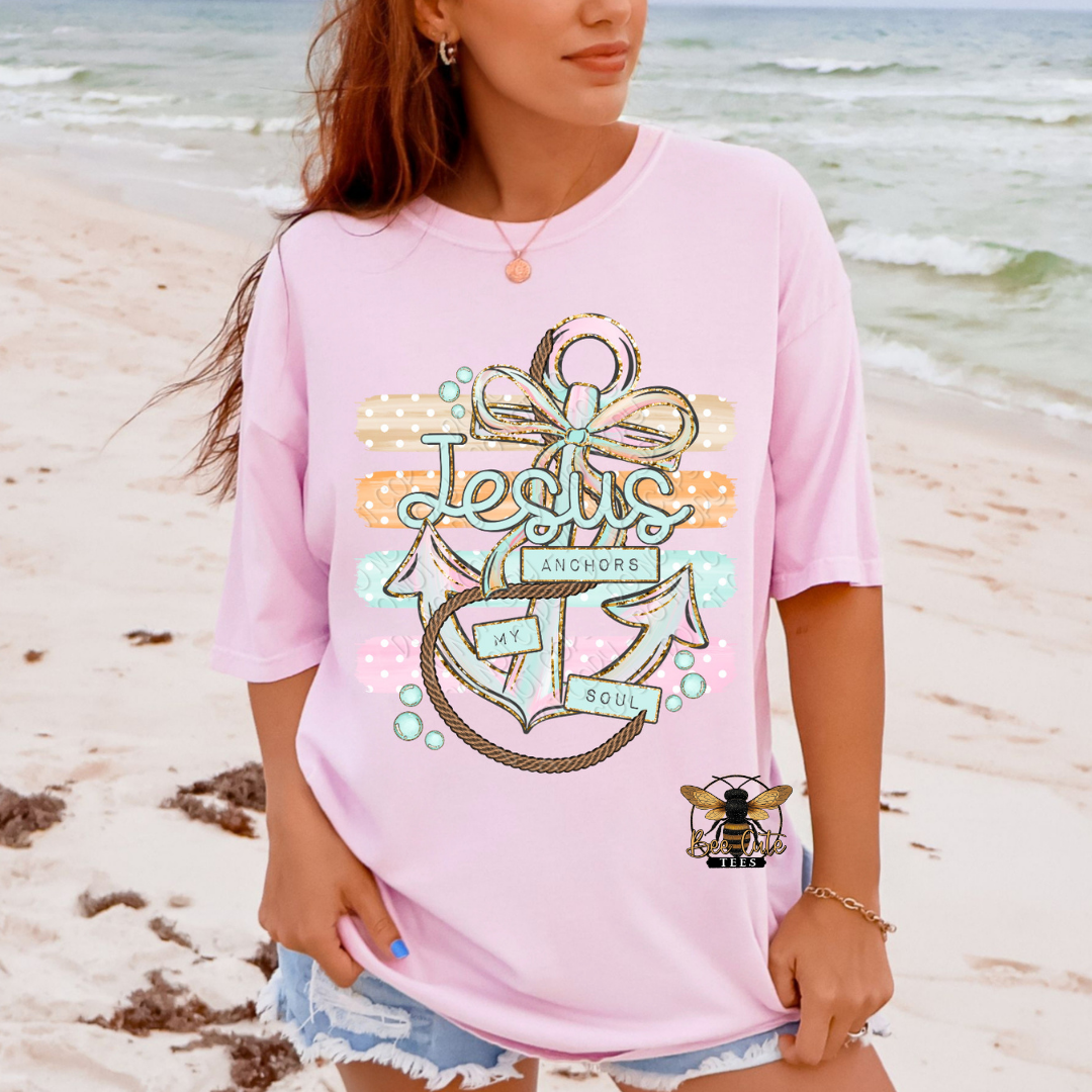Person wearing a pink t-shirt with a graphic design on a beach