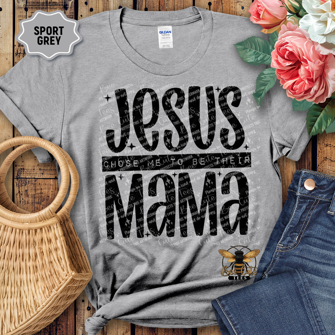 Gray t-shirt with 'Jesus chose me to be their mama' text, displayed with flowers and jeans on a wooden surface.
