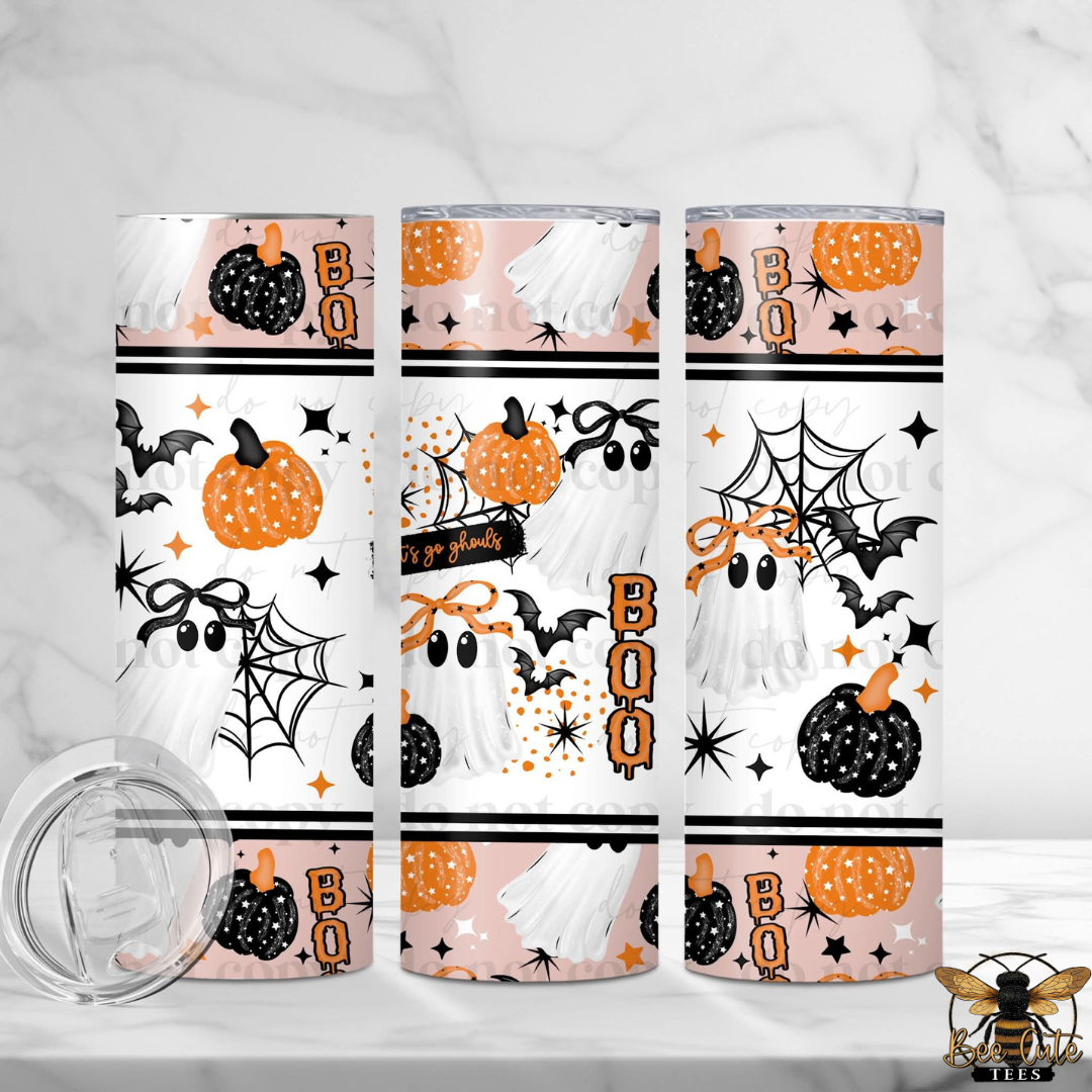 Three tall insulated tumblers with a Halloween-themed wrap design featuring ghosts, pumpkins, bats, spiderwebs, and the word 'BOO' in orange. A clear lid is shown separately in the lower left on a light marble surface.