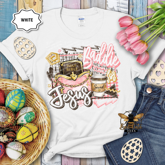 White t-shirt with 'Baddie' and 'Jesus' design, surrounded by Easter decorations on a wooden surface.