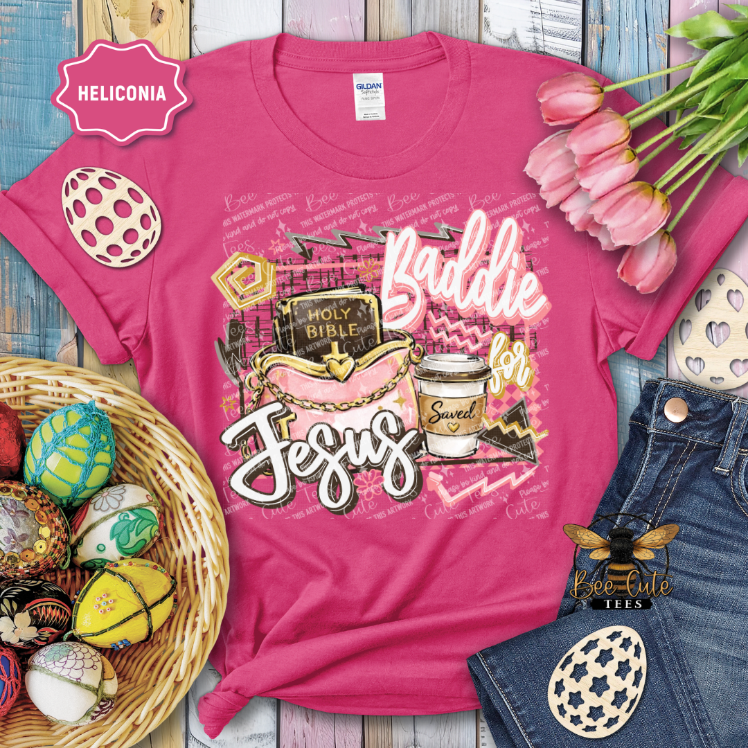 Pink t-shirt with 'Baddie for Jesus' design, surrounded by Easter decorations and jeans.