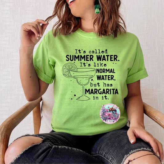 Person wearing a green t-shirt with a humorous quote about summer water, sitting on a chair.