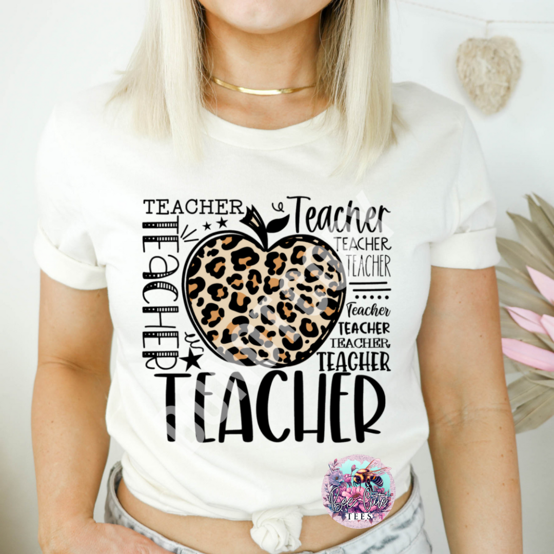 Person wearing a white t-shirt with a leopard print apple design and 'Teacher' text.