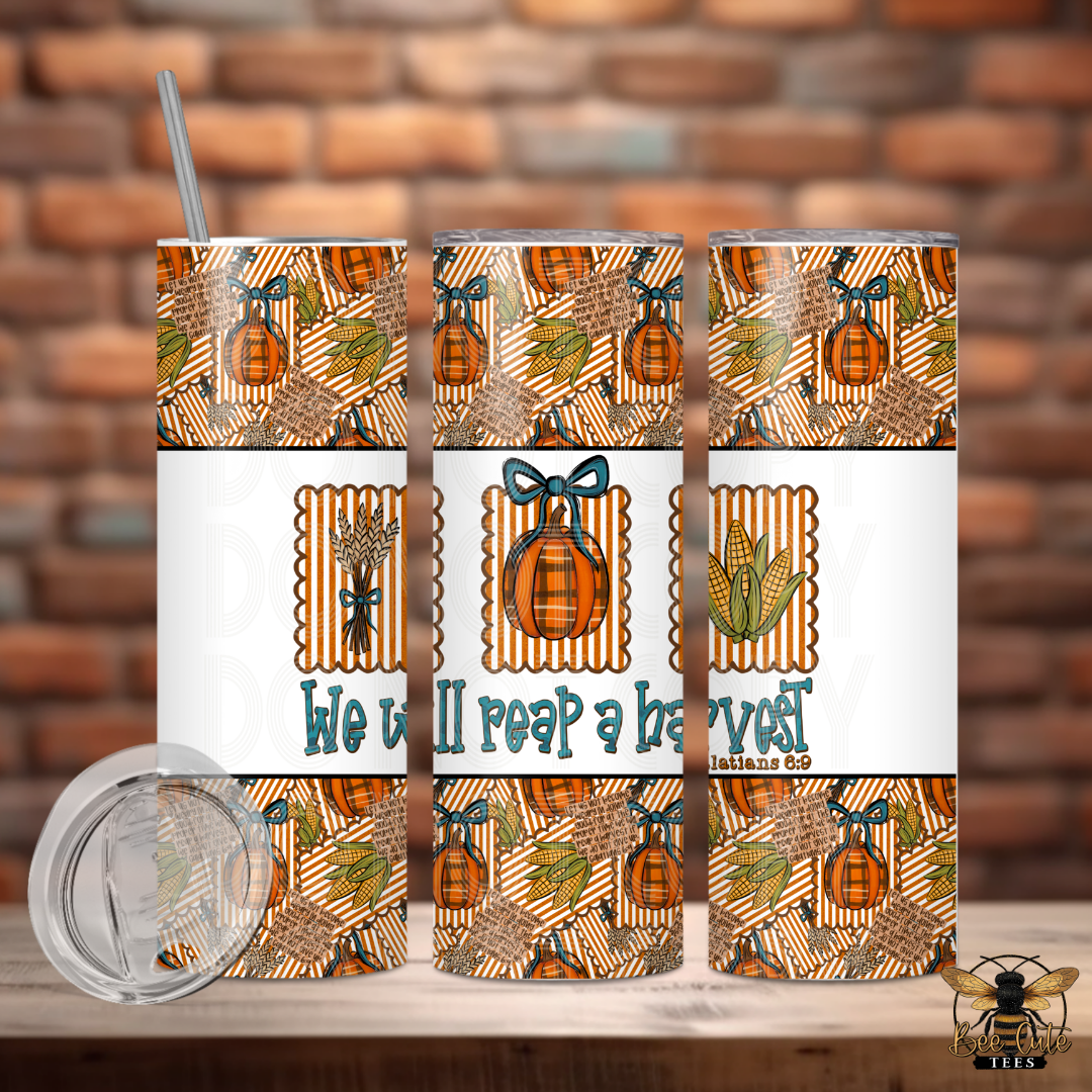 Three views of a 20 oz skinny tumbler with a clear lid and straw, featuring a fall harvest pattern with pumpkins, corn, wheat, and the text 'We will reap a harvest' on a white band. The tumbler is shown against a brick wall background with a wooden table surface.