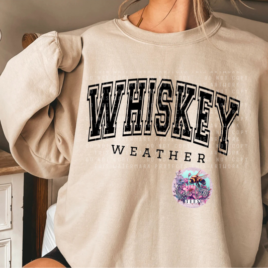 Beige sweatshirt with 'WHISKEY WEATHER' text and a colorful graphic on a person wearing it.