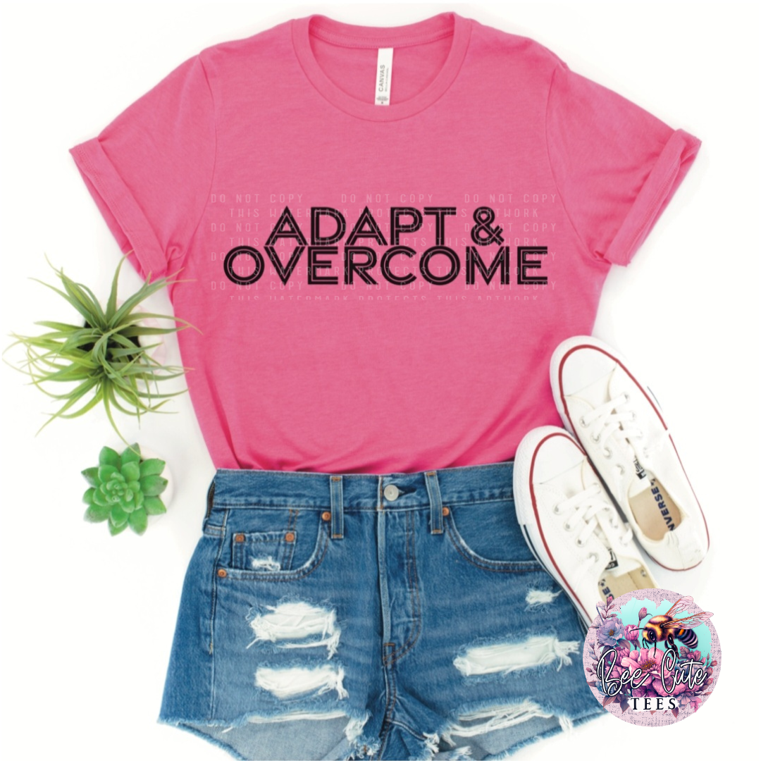 Pink t-shirt with 'Adapt & Overcome' text, denim shorts, white sneakers, and a plant on a white background.