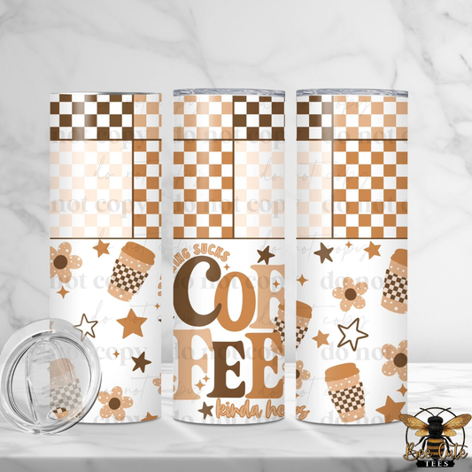 Three insulated tumblers with a brown and beige coffee-themed pattern, including checkerboard designs, stars, flowers, and the words 'TWO STAKES COFFEE', shown on a light marble surface with a clear lid in the foreground.