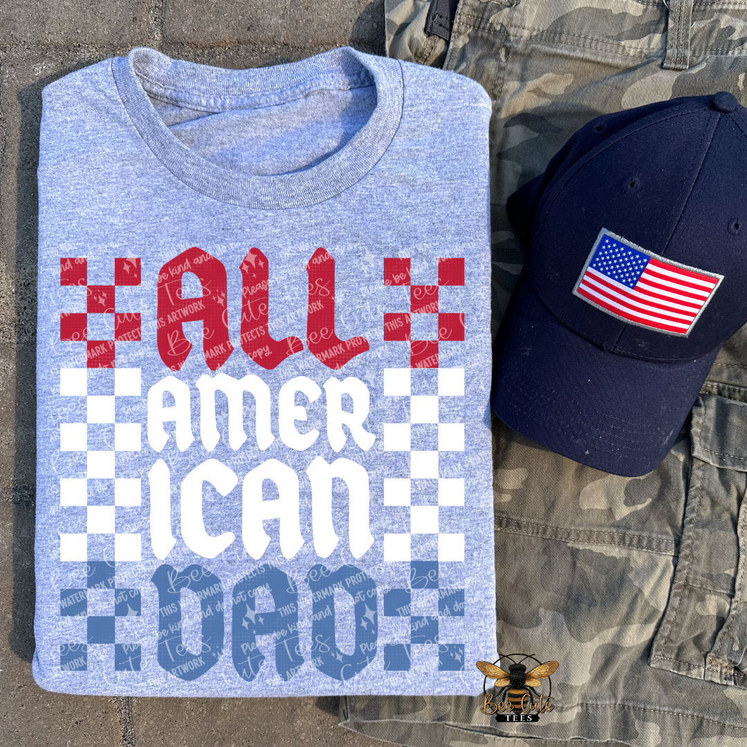 Blue t-shirt with 'ALL AMERICAN DAD' text and an American flag cap on camouflage pants.
