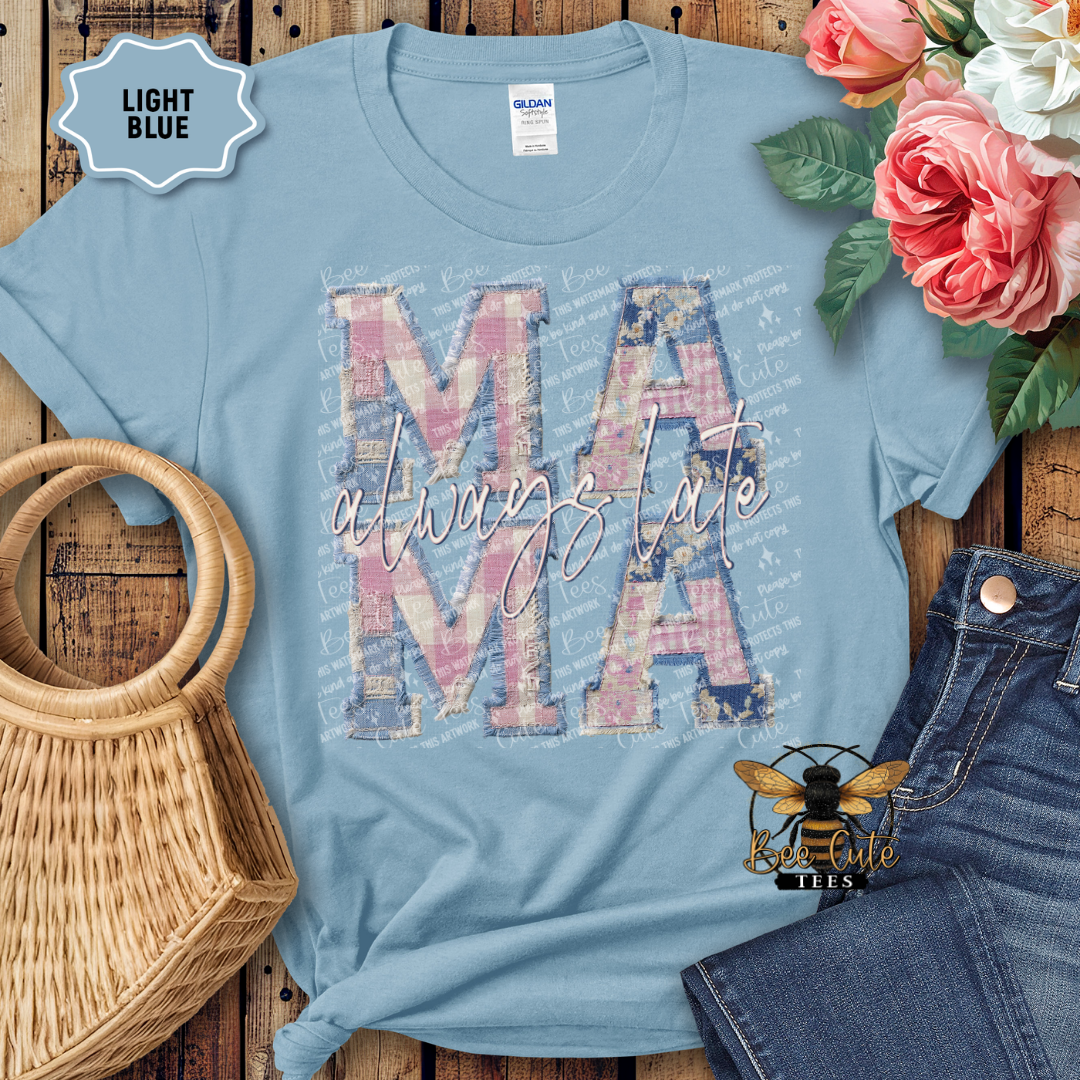 Light blue t-shirt with 'MAMA' design on a wooden surface with flowers and denim jeans.